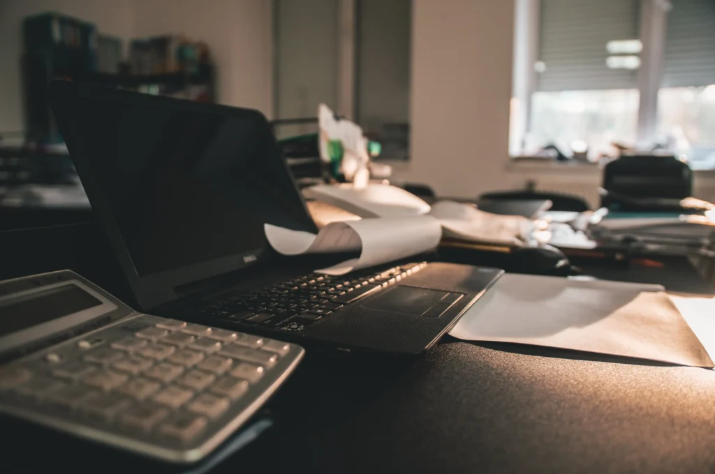 A laptop and keyboard on top of a desk.