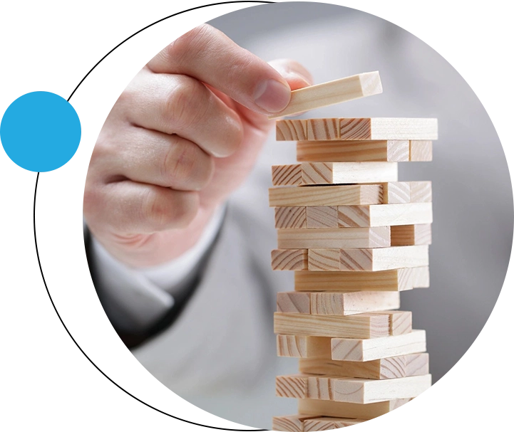 A person playing with wooden blocks on top of a tower.